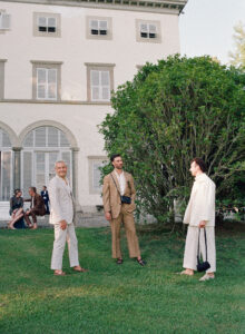 Wedding guests gather on the manicured lawns of Villa Grabau during a luxury destination wedding in Lucca, Tuscany. The historic Italian villa and its gardens create a timeless backdrop for cocktail hour, photographed by Mo Davis Photography.
